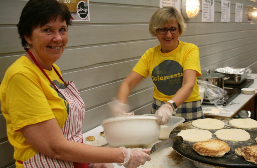 Folk kjem mykje berre for å smake dei gode nordlandskakene. Gurine Fosse klappar dei til på takka og Solveig Brekke Hetland passar steikinga. Foto: Anne-Britt Grindheim